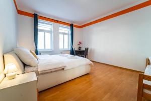 a bedroom with a white bed and a window at Lukas Apartments in Jáchymov