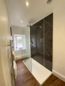 a bathroom with a shower with a glass door at Gordons in Cheddar