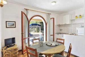 a kitchen and a dining room with a table and chairs at Villa Artistica trilo 3 in Capoliveri