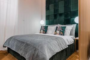 1 dormitorio con 1 cama con pared verde en Roberto Boutique Studio Apartman, en Zagreb