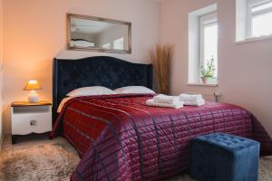 Schlafzimmer mit einem Bett mit einer roten Decke und einem Spiegel in der Unterkunft Kivi apartamentai Palangoje in Palanga