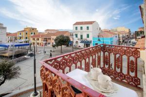 una mesa con 2 tazas y platillos en un balcón en Romeo and Juliet Affittacamere, en Santa Teresa Gallura