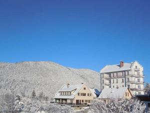 a large building with snow on it in front of a mountain at Les 4 Montagnes in Villard-de-Lans