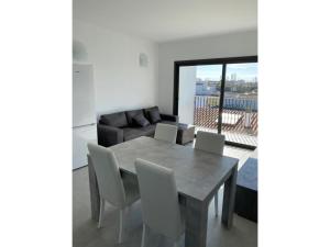 a dining room with a table and chairs and a couch at Giuliano Superior 4 personas in Empuriabrava