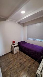 1 dormitorio con 2 camas y ventana en Cabaña FEMIBA 4 en El Calafate