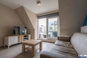 a living room with a couch and a tv at Le Roulis 0501 - vakantie appt 6p in De Panne
