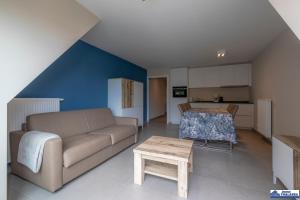 a living room with a couch and a table at Le Roulis 0501 - vakantie appt 6p in De Panne