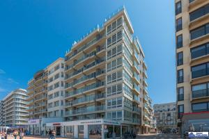 a tall building with people walking in front of it at Le Roulis 0501 - vakantie appt 6p in De Panne