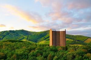 a building on a hill with a rainbow in the background at The Westin Rusutsu Resort in Rusutsu