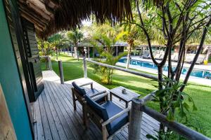a porch with two chairs and a table and a pool at Hotel VilaVeraTheresa in Fortim