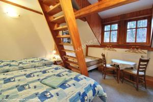 1 dormitorio con 1 cama, escalera y escritorio en Chata Artur, en Černý Důl
