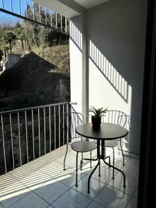 einen Balkon mit einem Tisch und 2 Stühlen auf einer Veranda in der Unterkunft Riva 5 in Lugano