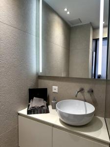 ein Badezimmer mit einem großen weißen Waschbecken und einem Spiegel in der Unterkunft Riva 5 in Lugano