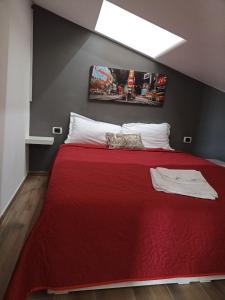 1 dormitorio con 1 cama con manta roja en Attico al Gallitello en Potenza