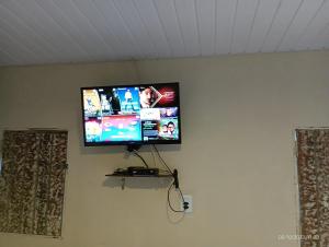 uma televisão de ecrã plano pendurada numa parede em Pousada Cantinho do Dodó em Mulungu