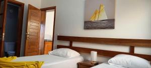 - une chambre avec 2 lits et un voilier sur le mur dans l'établissement Hotel Viajante, à Tarrafal