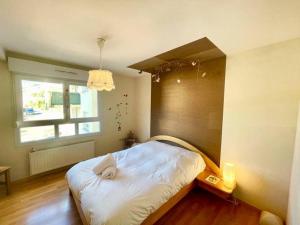 a bedroom with a large white bed with a window at Au nid de cigogne avec garage à Kaysersberg in Kaysersberg