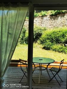 a table and two chairs sitting on a porch at Au nid de cigogne avec garage à Kaysersberg in Kaysersberg