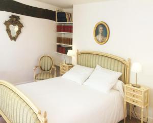 a bedroom with a white bed and a picture on the wall at Le Moulin de Vaugien in Saint-Rémy-lès-Chevreuse
