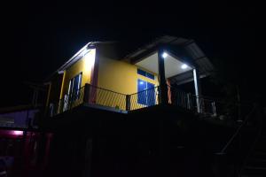 uma casa amarela com uma varanda à noite em Hira Panidihing Homestay em Sibsāgar