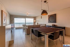 a dining room and living room with a table and chairs at Albert I 804 in De Panne