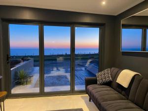 a living room with a couch and a view of the ocean at Seaview Stay in Peacehaven