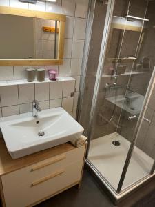 uma casa de banho com um lavatório e um chuveiro em Ferienwohnung im idyllischen Gulfhof em Krummhörn