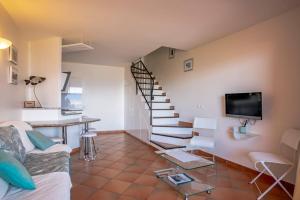 Una sala de estar con escalera y televisor. en Les Hauts de Pavellone, en Porto Vecchio
