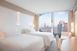 Postel nebo postele na pokoji v ubytování The Westin Hamburg Elbphilharmonie