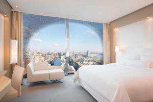 a bedroom with a white bed and a large window at The Westin Hamburg in Hamburg
