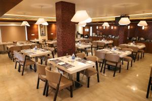 a dining room with tables and chairs and lights at Anukulas Residency - Vellore in Vellore