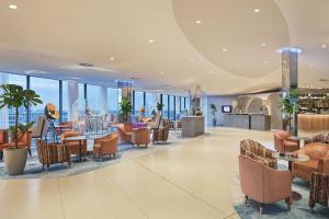 una hall con sedie, tavoli e finestre di The Westin Hamburg ad Amburgo