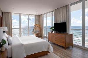 sypialnia z łóżkiem i telewizorem oraz niektóre okna w obiekcie The Westin Fort Lauderdale Beach Resort w mieście Fort Lauderdale