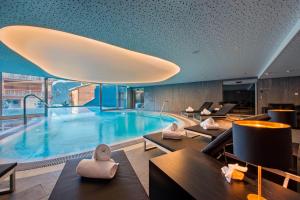 Una gran piscina en una habitación de hotel con sillas. en W Verbier, en Verbier