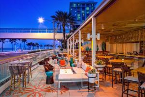 un patio del hotel con mesas y sillas y la playa en The Westin Fort Lauderdale Beach Resort en Fort Lauderdale