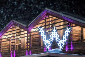 ein Haus mit lila Lichtern an der Seite in der Unterkunft W Verbier in Verbier
