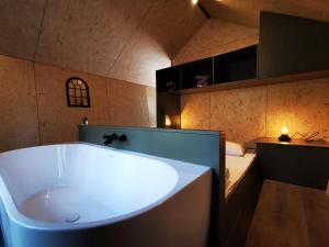 a large bath tub in a room with a bed at Diamond Suite in the woods in Holten