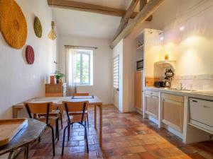 uma cozinha com mesa e cadeiras num quarto em Le Mas Réséda em Goult