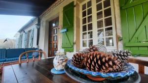 a table with a bowl of pine cones on it at L'Ostal de Gagnac in Gagnac-sur-Cère