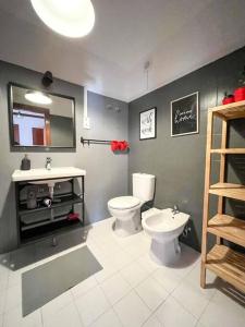 La salle de bains est pourvue de toilettes, d'un lavabo et d'un miroir. dans l'établissement Esplanada - Zona Central-Estacionamento e Wifi Gratuito-Perto Praias, à Setúbal