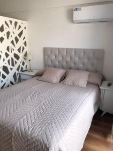 1 dormitorio con 1 cama grande y cabecero blanco en Rosarioalquilertemporario en Rosario
