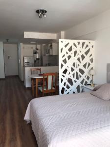 1 dormitorio con cama, mesa y cocina en Rosarioalquilertemporario en Rosario