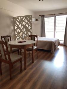 1 dormitorio con 1 cama, mesa y sillas en Rosarioalquilertemporario en Rosario