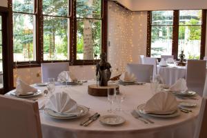 a dining room with a table with white tablecloths and glasses at McArthur Manor in Blairgowrie