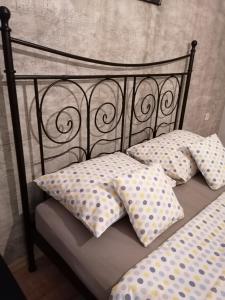 uma cama preta com almofadas de bolinhas em Stan na dan em Pozarevac