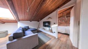uma sala de estar com um sofá, uma televisão e uma cama em Due passi dal mare em Montecorice