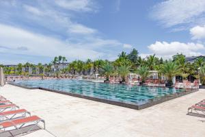 a pool at a resort with chairs and palm trees at Terrou-Bi in Dakar