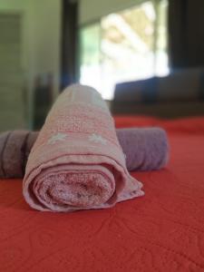 a pink towel sitting on top of a bed at Sítio Família Morais in Salvaterra