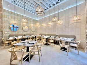 a dining room with tables and chairs and chandeliers at Soho Boutique Cádiz in Cádiz