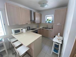 a small kitchen with a white counter and a microwave at Seafront Beach House in Meneou